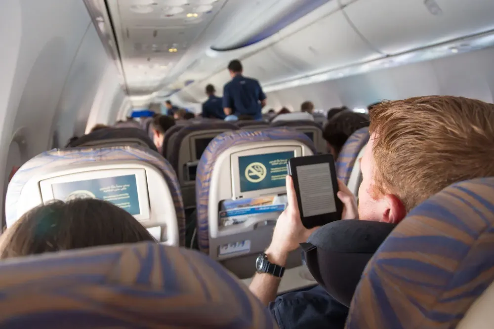 man reading kindle on plane.
